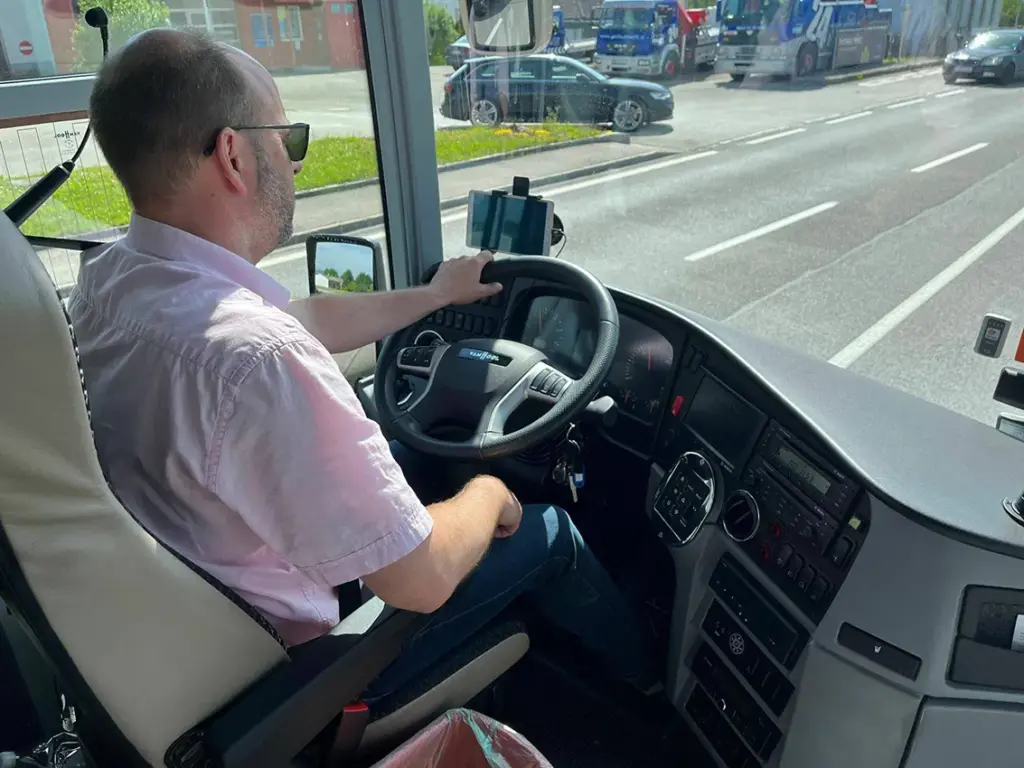 Eine Nahaufnahme eines auf die Straße konzentrierten Busfahrers von innen fotografiert.